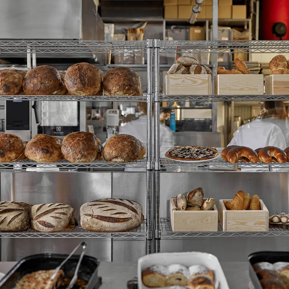 Freshly baked bread and pastries on racks in Eska bakery.